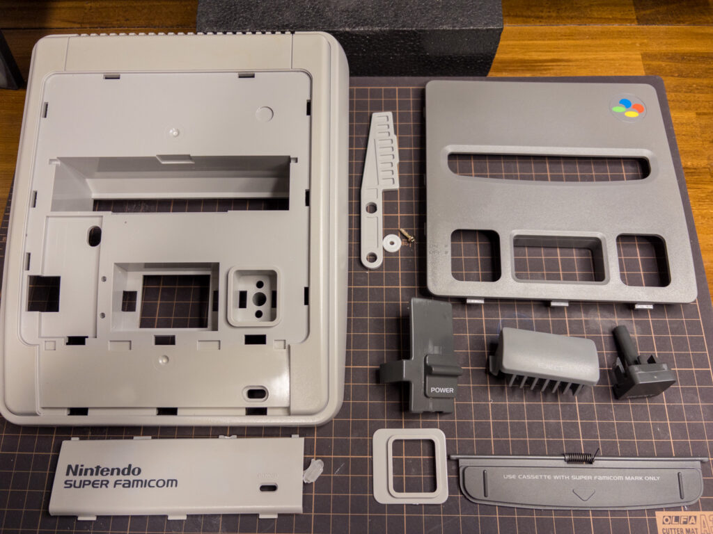 スーパーファミコン分解。
外装上側のパーツを全て外して並べた。